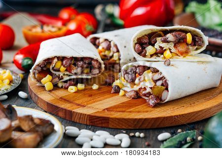 Nice Vegetarian Burrito Over Black Table On Wooden Board.