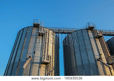 Agricultural Silos Against Blue Sky. Steel grain silos used to store grain.