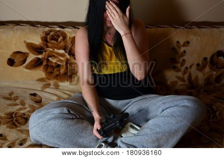 The Girl Sitting On The Couch And Show Facepalm Sign, Playing On The Game Console