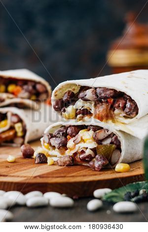 Nice Vegetarian Burrito Over Black Table On Wooden Board.