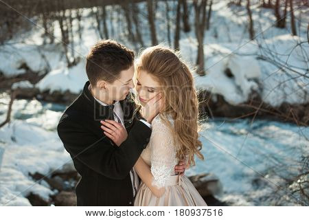 Beautiful couple in love honeymoon in the spring outdoors on a background of autumn nature and a river at sunset