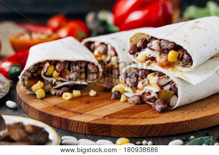 Nice Vegetarian Burrito Over Black Table On Wooden Board.