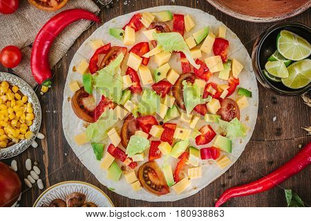 Tortilla With Salad Over It, Surrounded By Ingredients.
