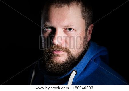 Solid bearded middle-aged man portrait on black background