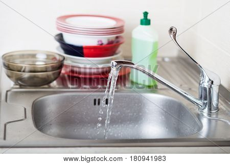 Cleaning dishware kitchen sink sponge washing dish. Close up of female hands in yellow protective rubber gloves washing