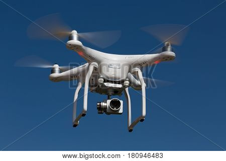 Niedernhausen Germany - April 9 2017: DJI Phantom 3 Standard Quadcopter flying into the blue sky. Low angle view.