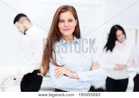 Happy businesswoman with colleagues in the background in modern office