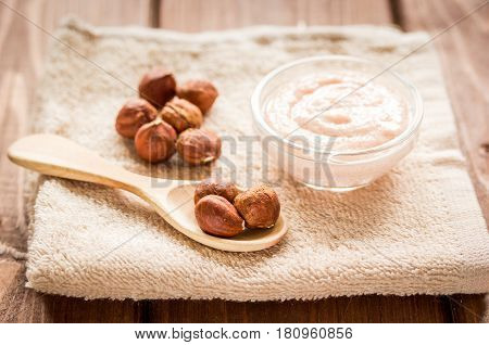 organic cosmetic for women body care with natural huzelnut scrub on desk background