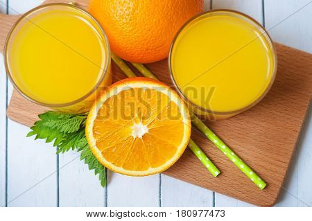 Orange juice in glass with mint, fresh fruits on white background