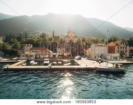 Prcanj, Montenegro The Bay of Kotor. Church of the Nativity of the Virgin. Newlyweds are walking around the church. Aerial photography.