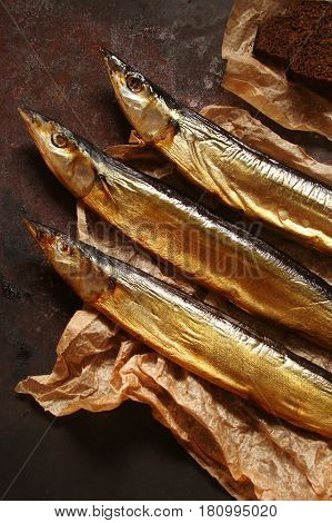 Fish saury smoked paper and the brown concrete background