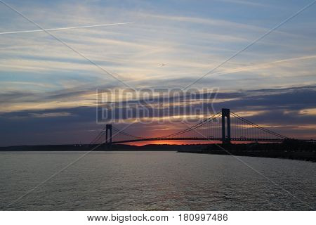 NEW YORK - APRIL 10, 2017: Verrazano Bridge at sunset in New York .The Verrazano Bridge is a double-decked suspension bridge that connects the boroughs of Staten Island and Brooklyn
