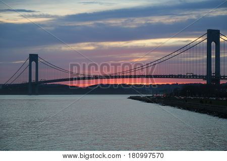 NEW YORK - APRIL 10, 2017: Verrazano Bridge at sunset in New York .The Verrazano Bridge is a double-decked suspension bridge that connects the boroughs of Staten Island and Brooklyn