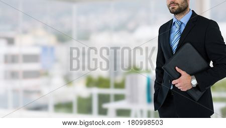 Digital composite of business man with carper on burred background