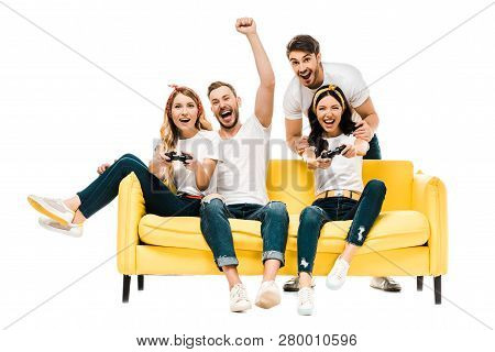 Excited Young Friends Playing With Joysticks And Smiling At Camera Isolated On White