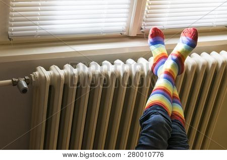 Heavy Duty Radiator - Central Heating. Woman With Colorful Socks Enjoying Winter In Warm, Cozy Room 