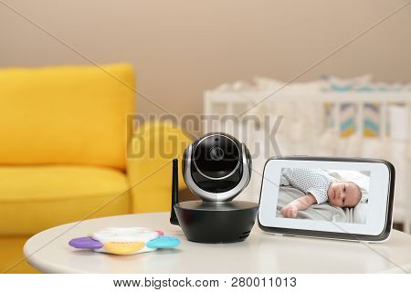 Modern Security Cctv Camera And Monitor With Baby's Image On Table. Space For Text