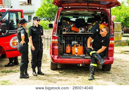 Poznan, Poland - June 9, 2018: Three Firefighters Having A Conversation By A Fire Truck During The B