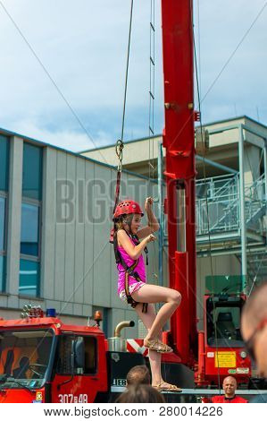 Poznan, Poland - June 9, 2018: Girl With Safety Helmet Climbing A Hanging Ladder During The Bezpiecz