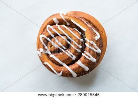 Homemade Fresh Cinnamon Roll / Bun With Cream Sauce Served With Marble Board.