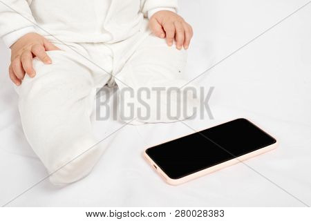 Baby Holding A Mobile Phone Isolated On White Background