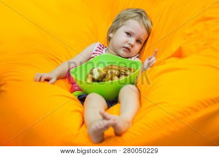 A Little Boy Wallows In An Orange Bean Bag Chair With A Green Basin Of Simple Cupcakes And Watches C