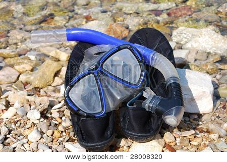 Un tuba et un masque portant sur le dessus de caoutchouc chaussures de nager sur la plage dans la baie de Spilia Meganissi Island
