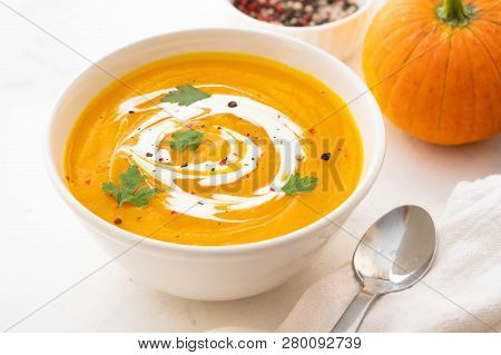Pumpkin Soup With Cream And Pumpkin Seeds Isolated On White Background. Autumn Concept.