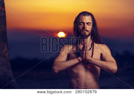 Yogi man meditating at sunset on the hills. Lifestyle emotional relaxation emotional concept spirituality harmony with nature 