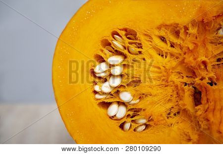 Tasty And Healthy And Fleshy Vegetable - Juicy, Bright Orange Pumpkin In A Cut With Seeds Close Up. 
