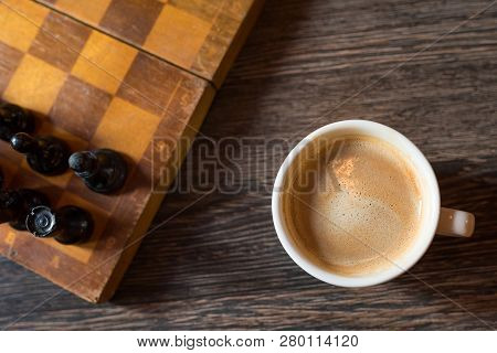 Cup Of Coffee And Chess-board By Close-up On A Wooden Background. Kind From Above.