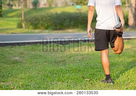 Young Athlete Man Streching In The Park Outdoor. Male Runner Warm Up Ready For Jogging On The Road O