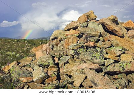 Kopiec i rianbow w pochmurne niebo