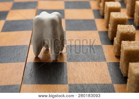 Oral Health. Healthy Tooth Against Sugar Army On Chessboard, Closeup