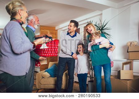 Grandmother And Grandfather Bring A Gift For Moving Into A New Apartment To Their Children