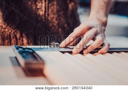 Woodwork And Furniture Making Concept. A Carpenter In The Workshop Marks Out And Installs The Furnit