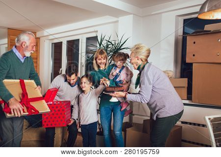 Grandmother And Grandfather Bring A Gift For Moving Into A New Apartment To Their Children
