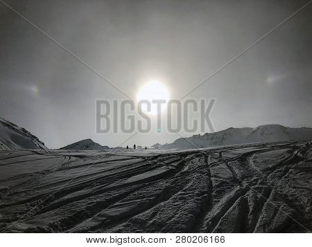 Several Ski Tracks Under A Low Sun