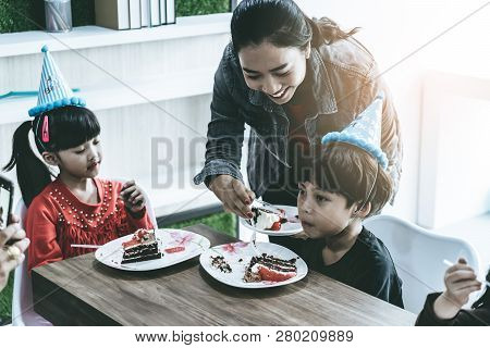 Mother Is Feeing Her Children Birthday Cake In A Brithday Party