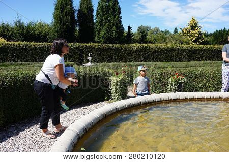 Dobrzyca, Poland - August 6, 2018: People Standing By A Water Fountain On The Hortulus Park In The S