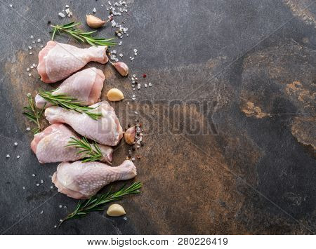 Chicken legs with spices and salt  ready for cooking on cutting board.