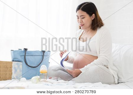 Pregnant Woman Preparing Hospital Bag Checklist And Making A Birth Plan From A Hospital That Has Ant