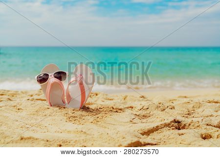 Pink And White Sandals, Sunglasses On Sand Beach At Seaside. Casual Fashion Style Flipflop And Glass