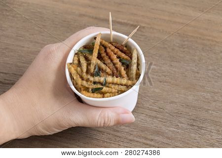 Woman's Hand Holding Disposable Cup Which Containing Bamboo Caterpillar, Worm Fried Crispy For Take-