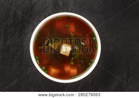 A Photo Of A Bowl Of Miso Shiru Soup With Tofu, Scallions, And Wakame Seaweed, Shot From Above On A 
