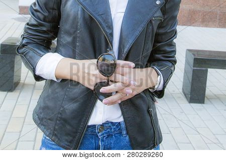 The Hands Of A Self-confident Businesswoman Hold Sunglasses.
