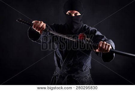 Powerful Ninja Portrait With Drawn Sword On A Dark