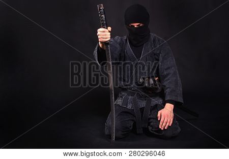 Tired Ninja In Kimono With Katana Sits On His Lap