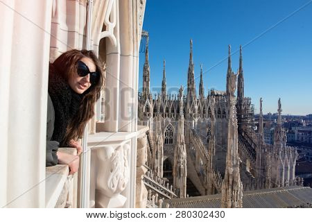 Young attractive woman posing on the roof of Milan Cathedral (Duomo di Milano), Italy. 