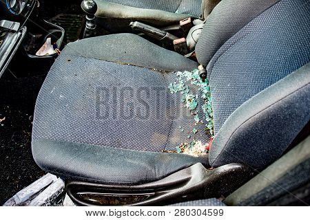 The Seat Of A Vandalized Car With Broken Smashed Glass Covering The Seat